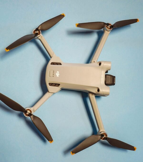 Modern drone with propellers displayed on a minimalist blue background, showcasing technology.